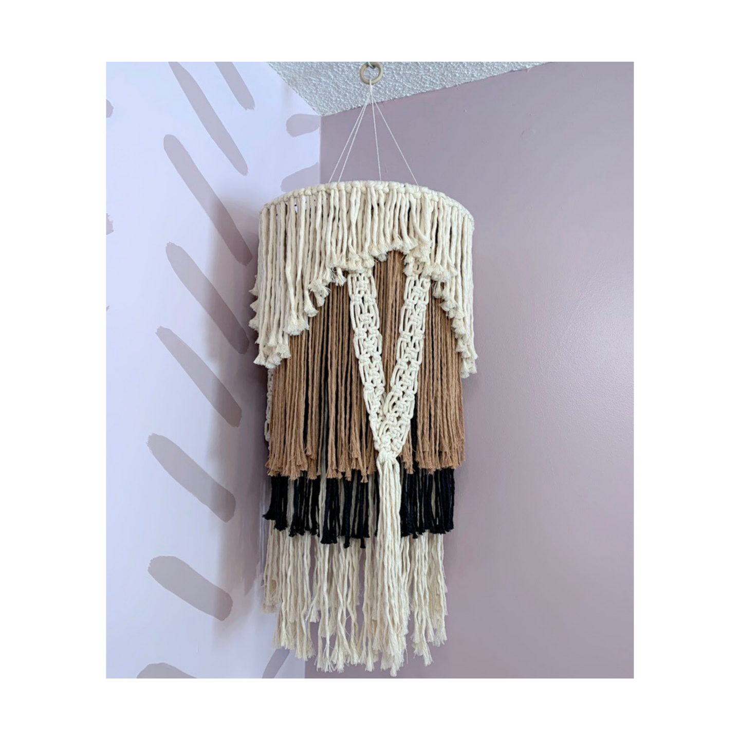 This eloquent chandelier looks stunning from an elevated ceiling or hung in the corner of any room. The multilayers of fringe are made with 100% recycled cotton cord.