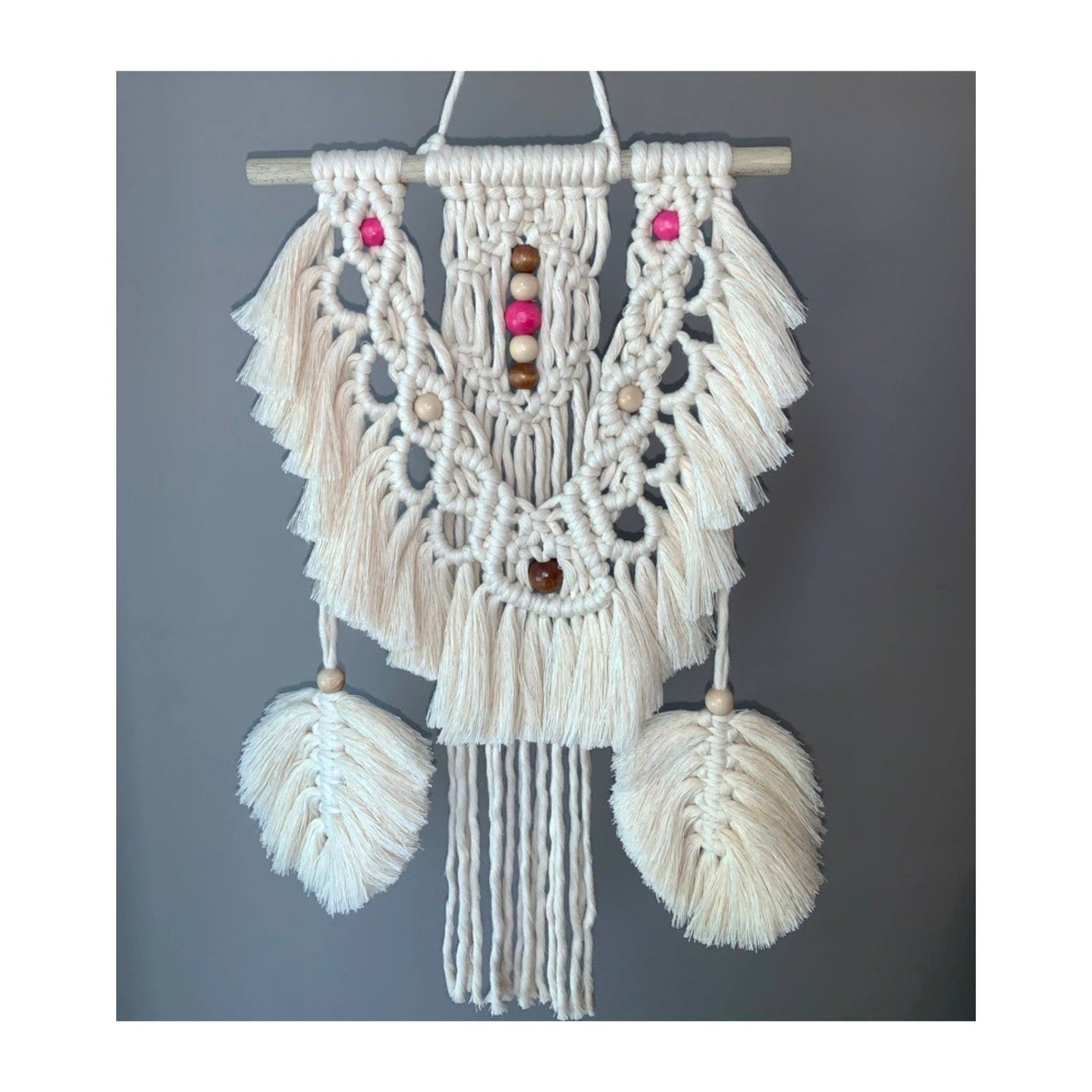 Exhibit this small whimsical macrame fiber art! It’s uniquely paired with two hanging macrame feathers on each side. Beads will be ALL tan. Option to change feather colors is available.