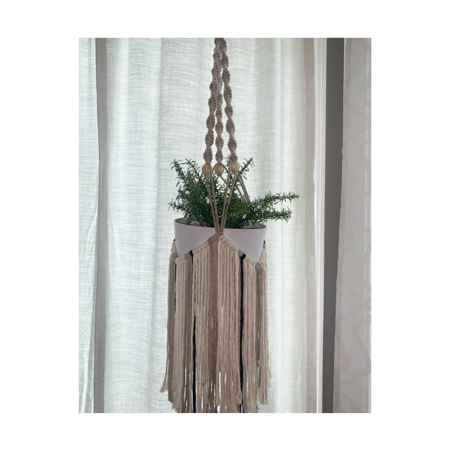 Macrame fringed plant hanger with multi colored fringe and a few accent beads.